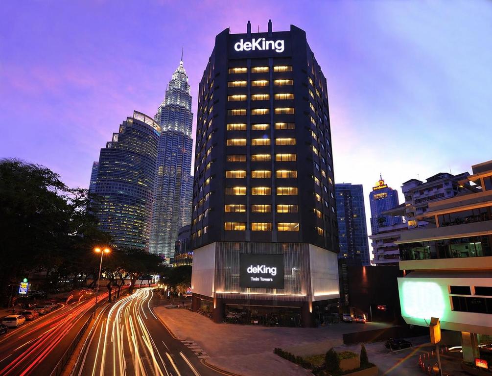 a tall building with a sign on it in a city at deKing Hotel Twin Towers by DK Hospitality in Kuala Lumpur