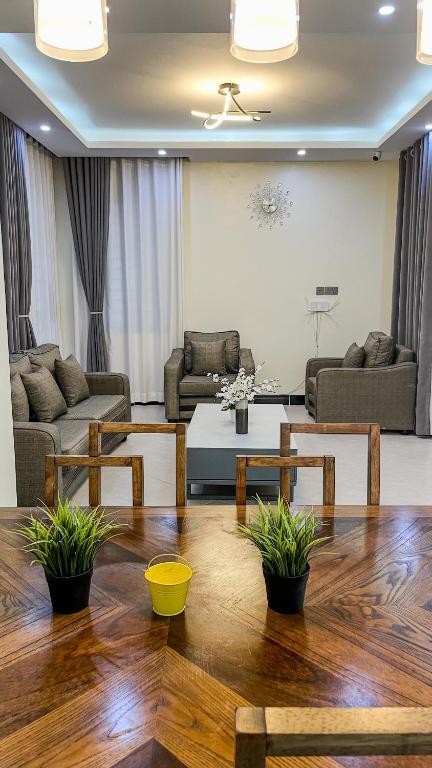 a living room with couches and a table and chairs at Bwebajja Hub in Bwebajja