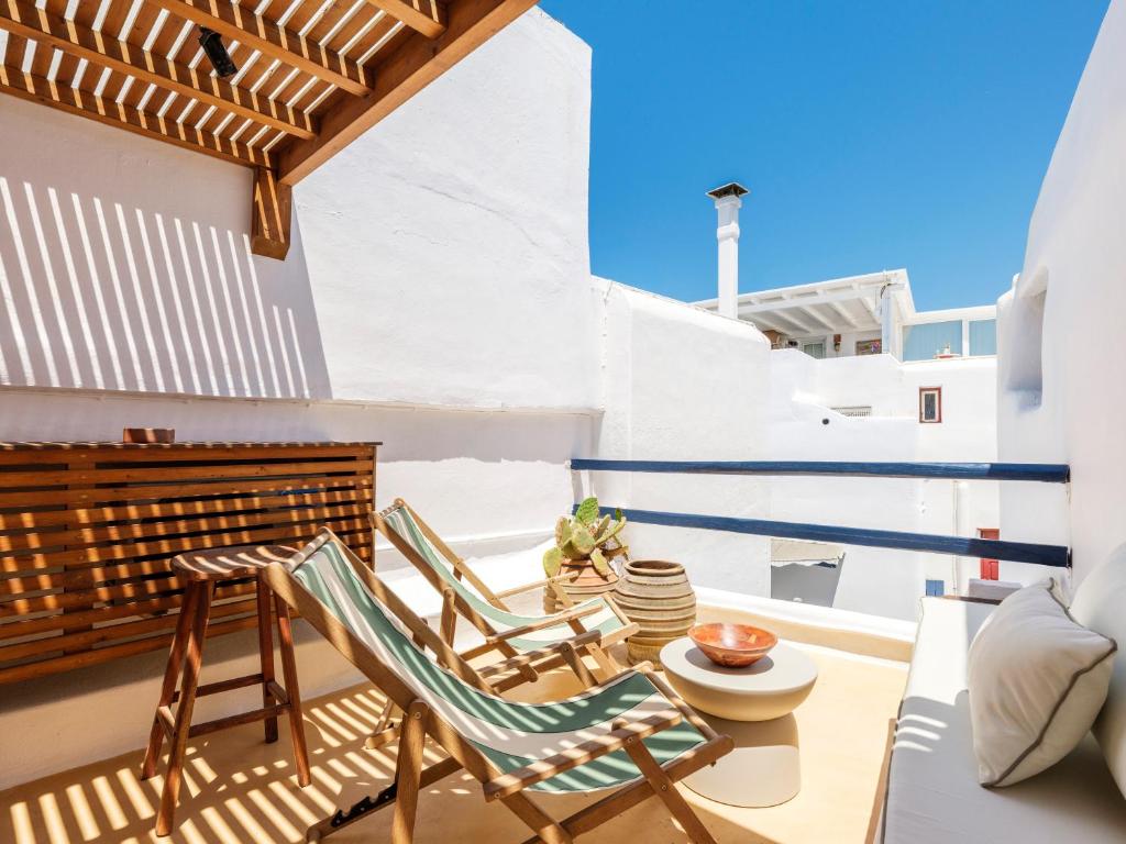 a balcony with chairs and a table on a house at SilVen Little Venice Stay, Mykonos Town in Mikonos