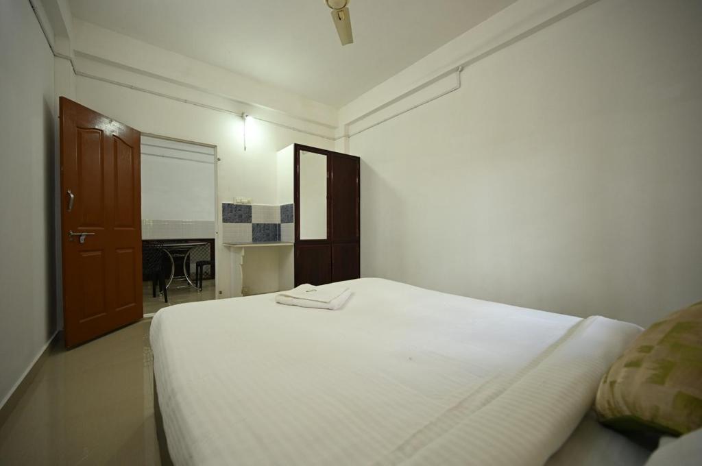 a bedroom with a white bed and a room with a piano at Norwegian Guest House in Anachal
