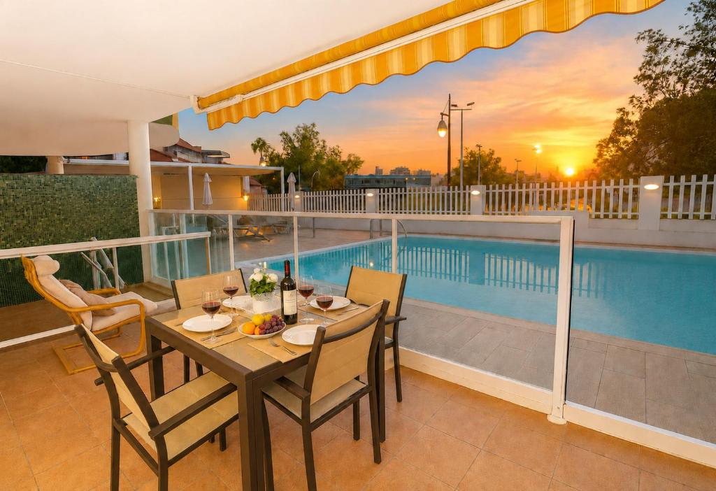 a table and chairs on a balcony with a pool at GOLDEN BEACH MOGAN in Puerto de Mogán