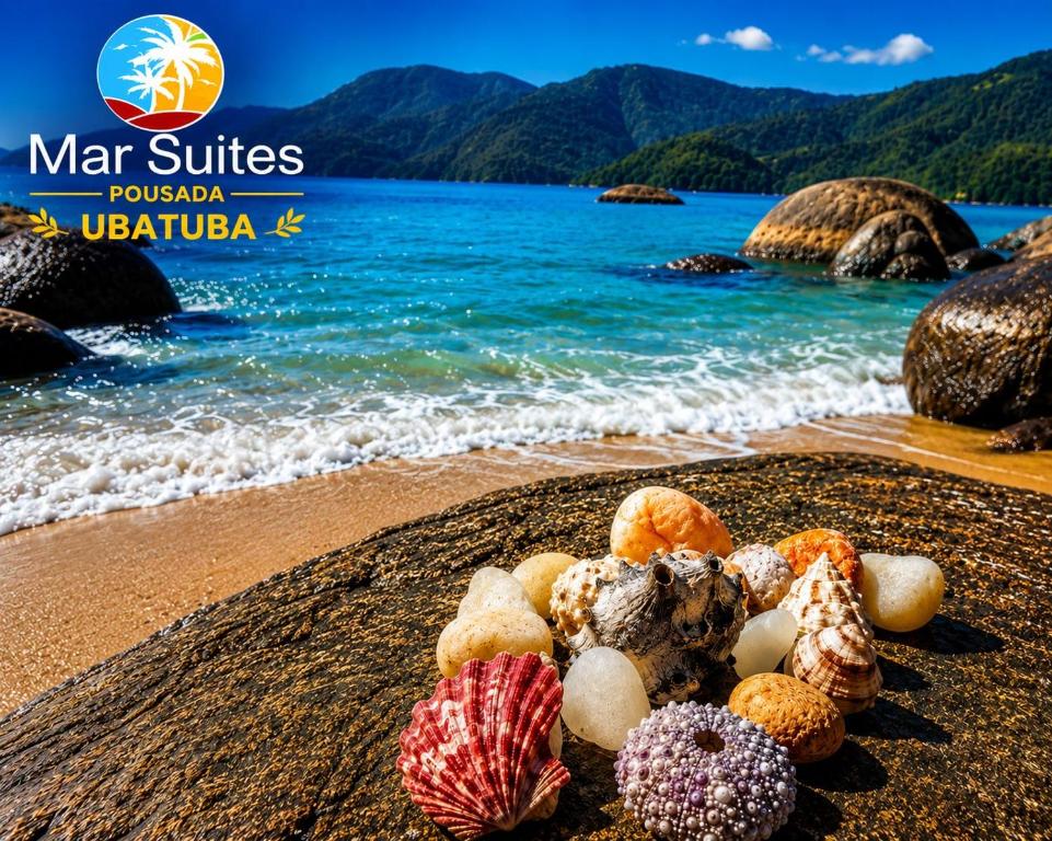 a pile of donuts on a beach next to the water at Mar Suites Tenório in Ubatuba