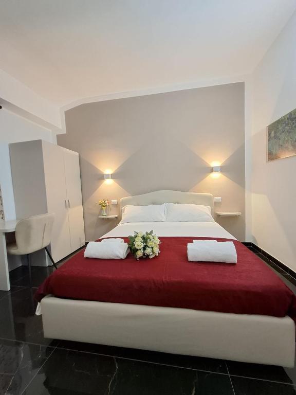 a bedroom with a large bed with a red blanket at Hotel Solferino in Brescia