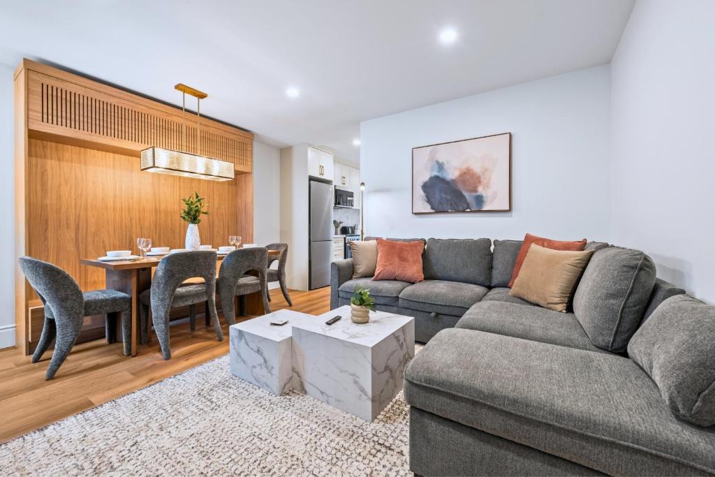 a living room with a couch and a table at Casa Hotels Gerrard Modern Downtown Suite in Toronto
