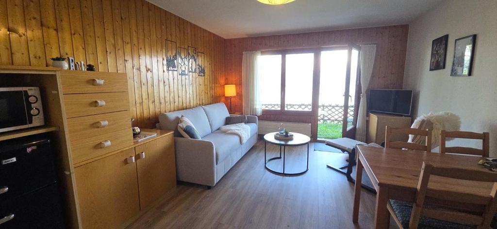 a living room with a couch and a table at Studio Bellevue Veysonnaz in Veysonnaz
