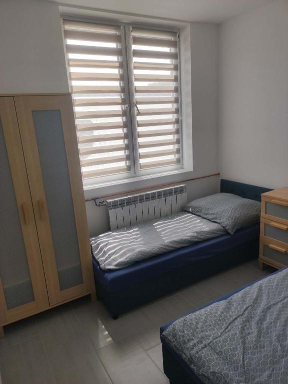 a bedroom with two beds and a window with blinds at Agroturystyka Gorajec Zagroble in Wólka Czarnystok