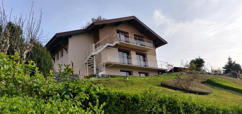 a house on top of a grassy hill at Le nid bucolique in Publier