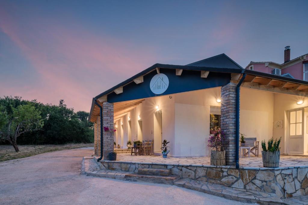 a house with a blue roof and a patio at MustBe CFU Studios in Danilia