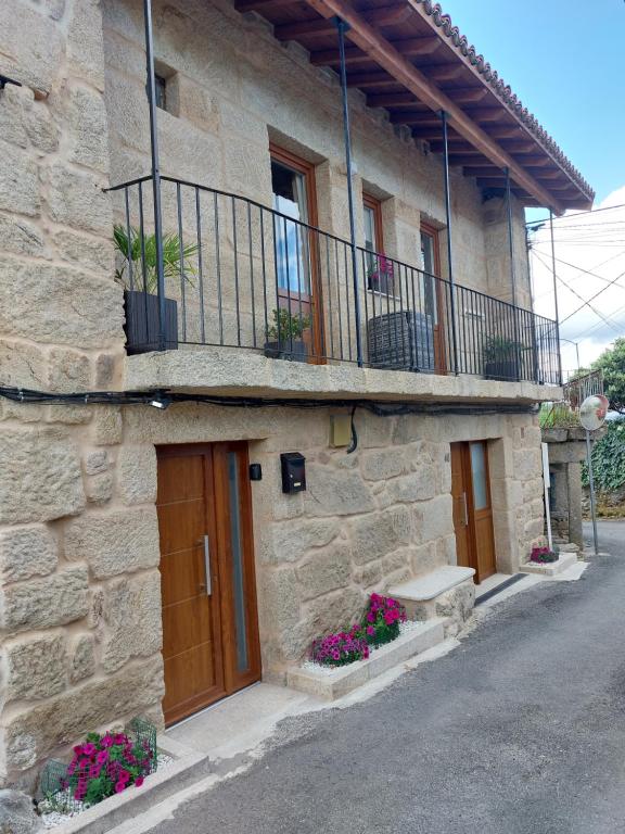 a stone building with a balcony and a door at Casa MENDEZ - ALLARIZ in Ourense