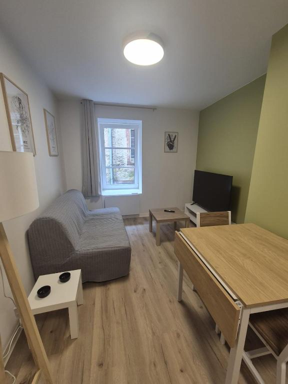 a living room with a bed and a table at Appartement cocooning Sierck-les-Bains in Sierck-les-Bains