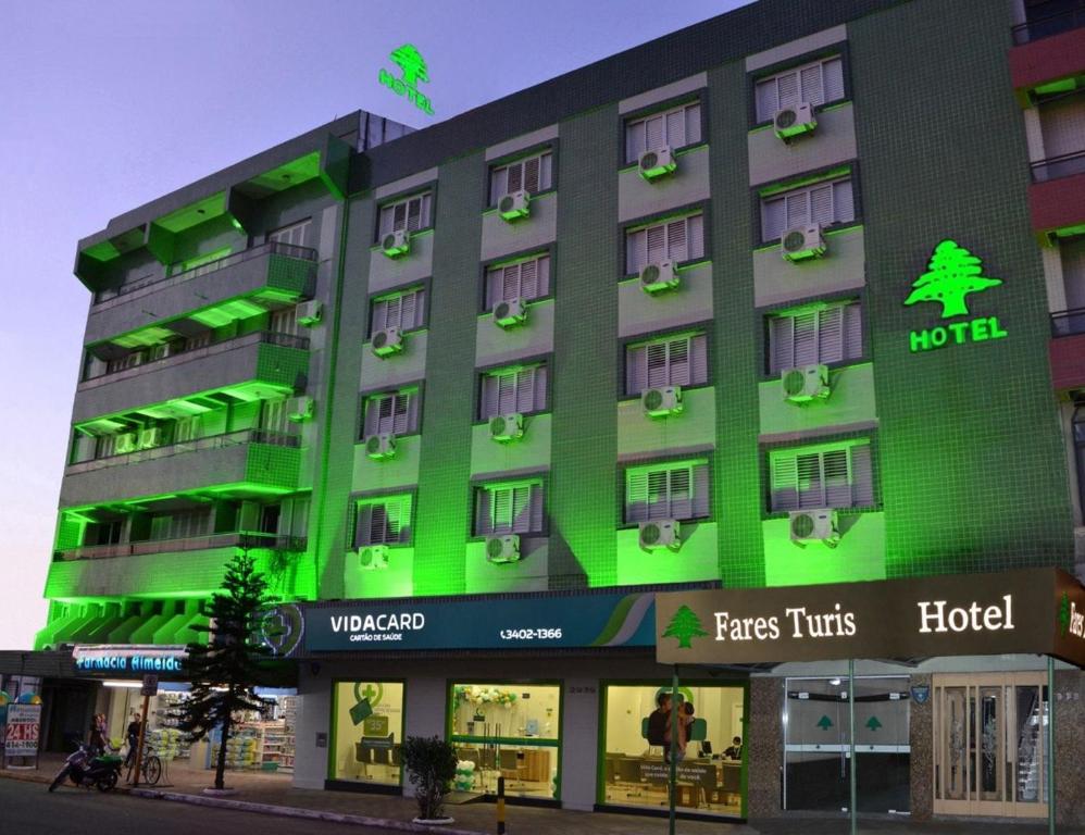 a hotel with green lights on the side of it at Fares Turis Hotel in Uruguaiana