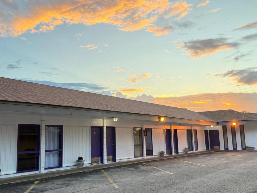 an empty parking lot in front of a building at Motel Masquerade in Marksville