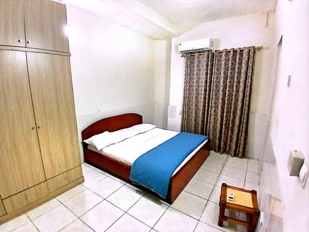 a small bedroom with a bed and a cabinet at Vesper Apt-Osu in Christiansborg