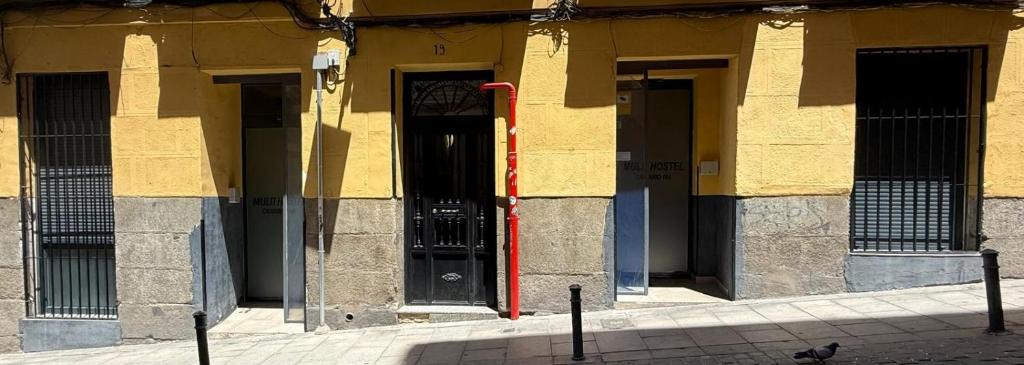 a building with a black door and a red pole at Hostel BM19 in Madrid