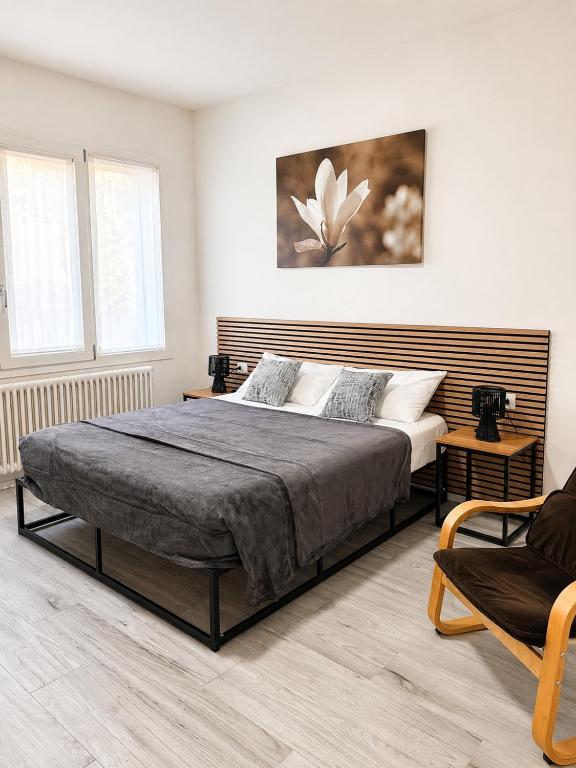 a bedroom with a large bed and a chair at Seicuori Padova - 2 Camere, 2 Bagni, Parcheggio in Padova