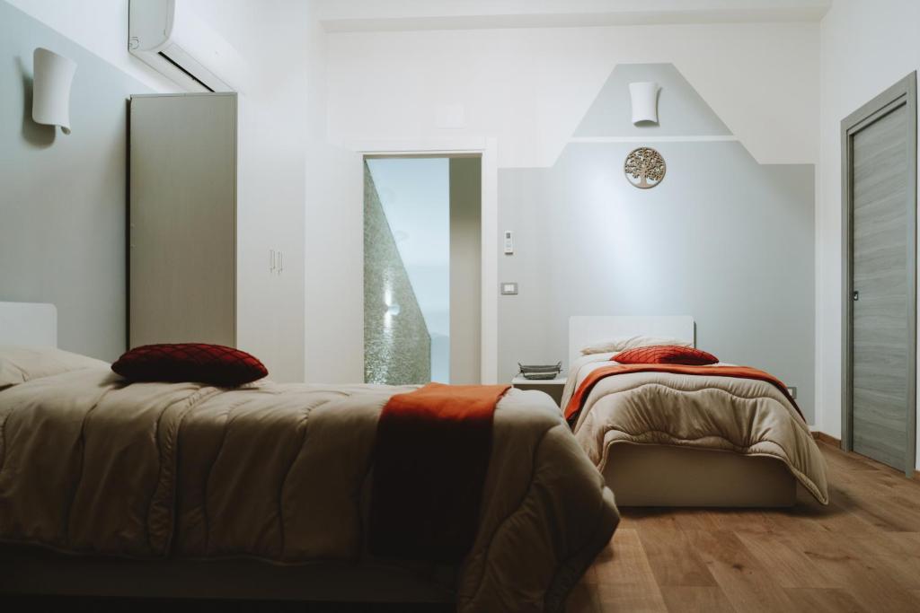 a bedroom with two beds and a large window at Aura Residence in San Biagio