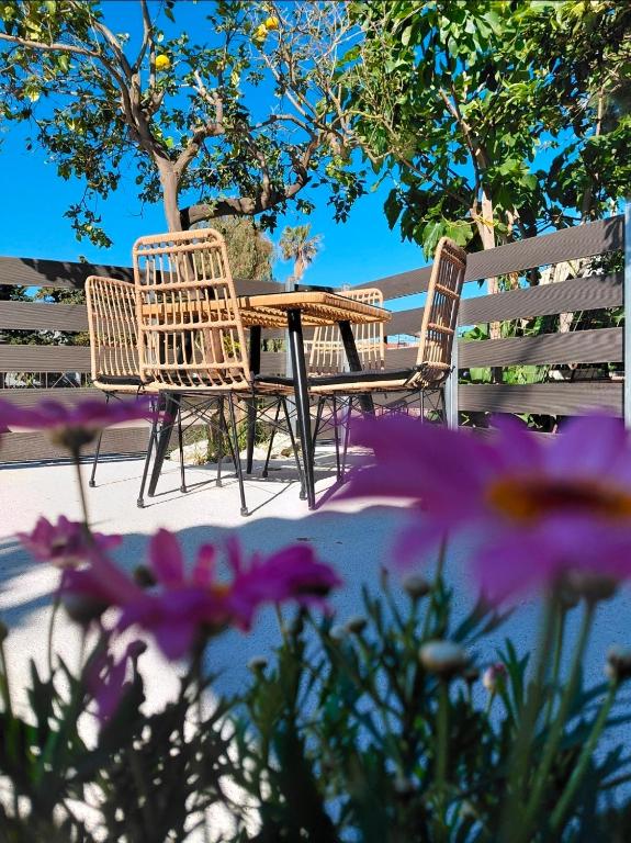 three chairs and a table in front of a fence at Pefanis House in Preveza