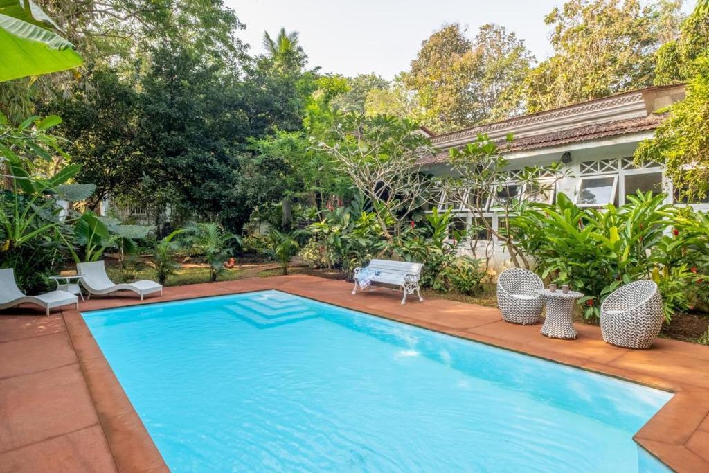 a swimming pool in front of a house at The Inner Temple - Moira, Goa in Mapusa