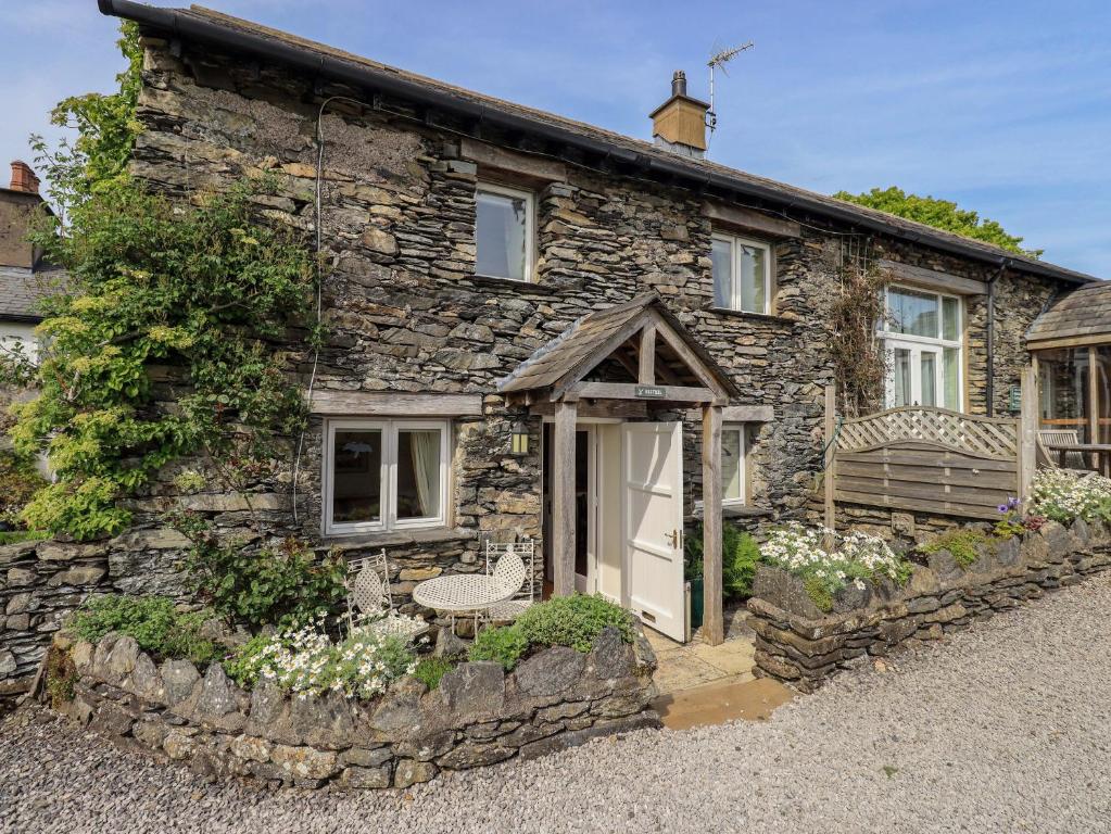 an old stone house with a white door at Kestrel Cottage in Grange Over Sands