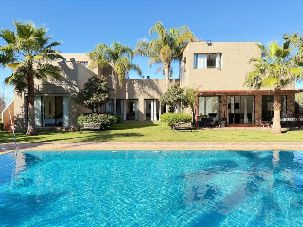 a large swimming pool in front of a house at Villa Serenity MARRAKECH in Oulad Mazoug