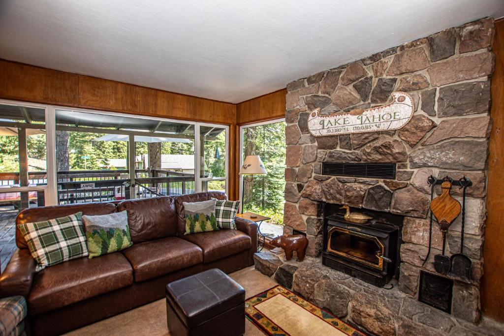 a living room with a couch and a stone fireplace at Holland By Hauserman Rentals in Homewood