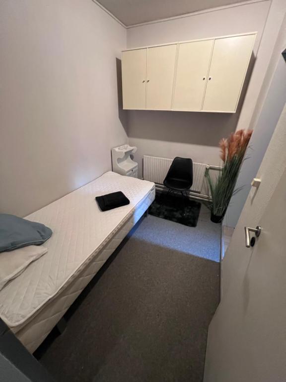 a small room with a bed and a chair at Skibbild in Vildbjerg