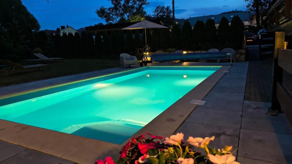 a swimming pool in a backyard at night at Willa Alpejska - basen, jacuzzi e-rowery w cenie przy min 2 nocach in Wisła