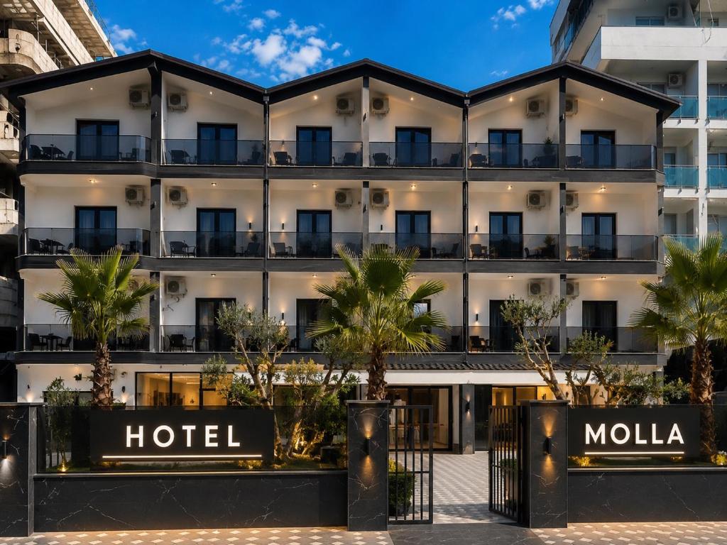 a hotel with palm trees in front of it at Molla Hotel Restorant in Shëngjin