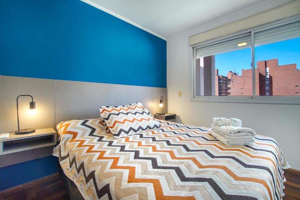a bedroom with a large bed and a window at Lofty Departamentos Temporarios in Córdoba