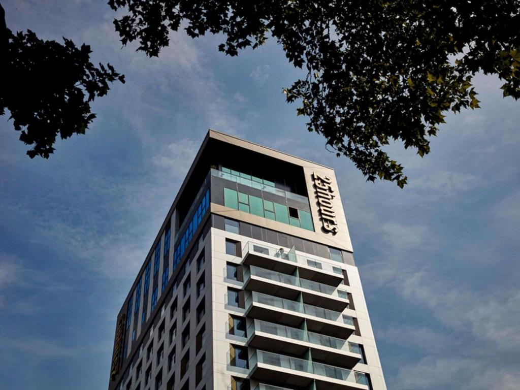 a tall white building with a sign on it at 25hours Hotel Das Tour in Düsseldorf