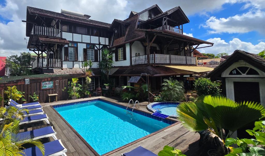 an exterior view of a house with a swimming pool at Greenheart Boutique Hotel in Paramaribo