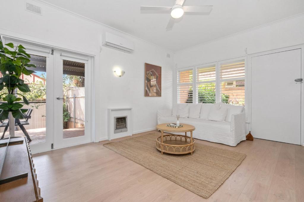 a living room with a white couch and a table at Oak and Olive - Glenelg in Glenelg