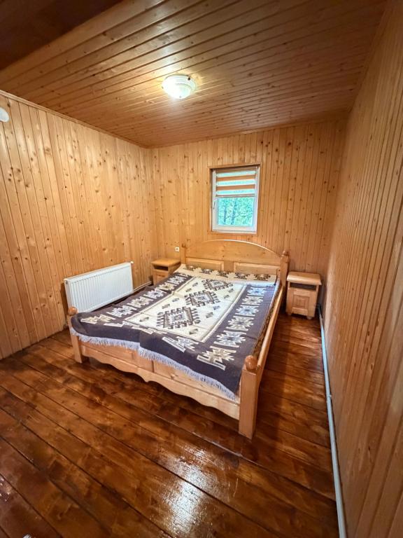 a bedroom with a bed in a wooden room at Садиба у Оксанки in Vorokhta