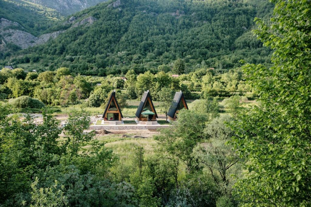 a building in the middle of a forest with mountains at Ujcevina Apartments in Donje Morakovo
