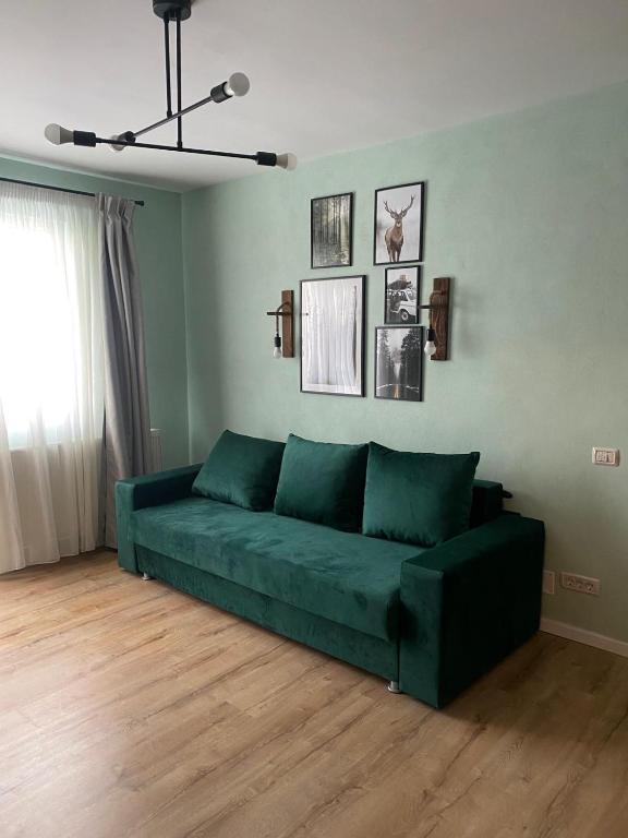 a green couch sitting in a living room at Apartament Tudor in Făgăraş