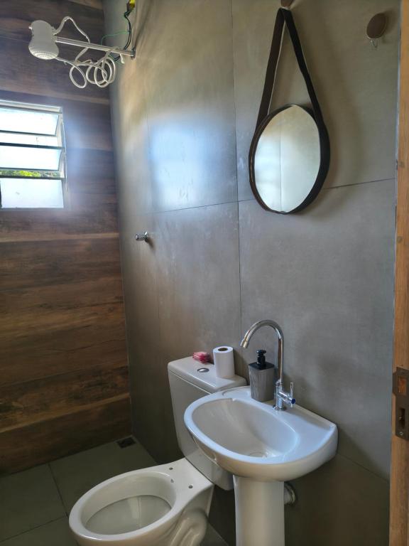 a bathroom with a sink and a toilet and a mirror at Apartamento Próximo ao UNASP in Engenheiro Coelho