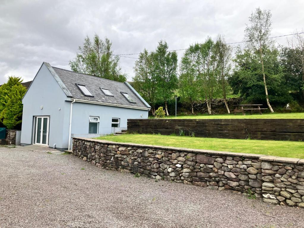 a white house with a stone wall at Silver Birch House in Laune Bridge