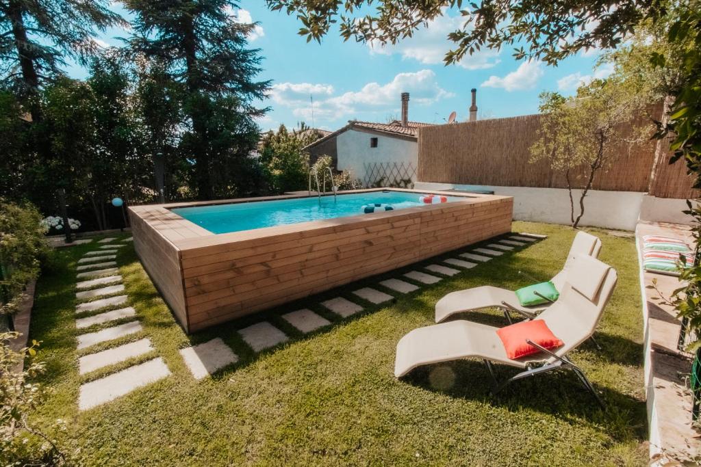 a swimming pool in a yard with two chairs at DONNA LAURA - Holiday Home in Arezzo