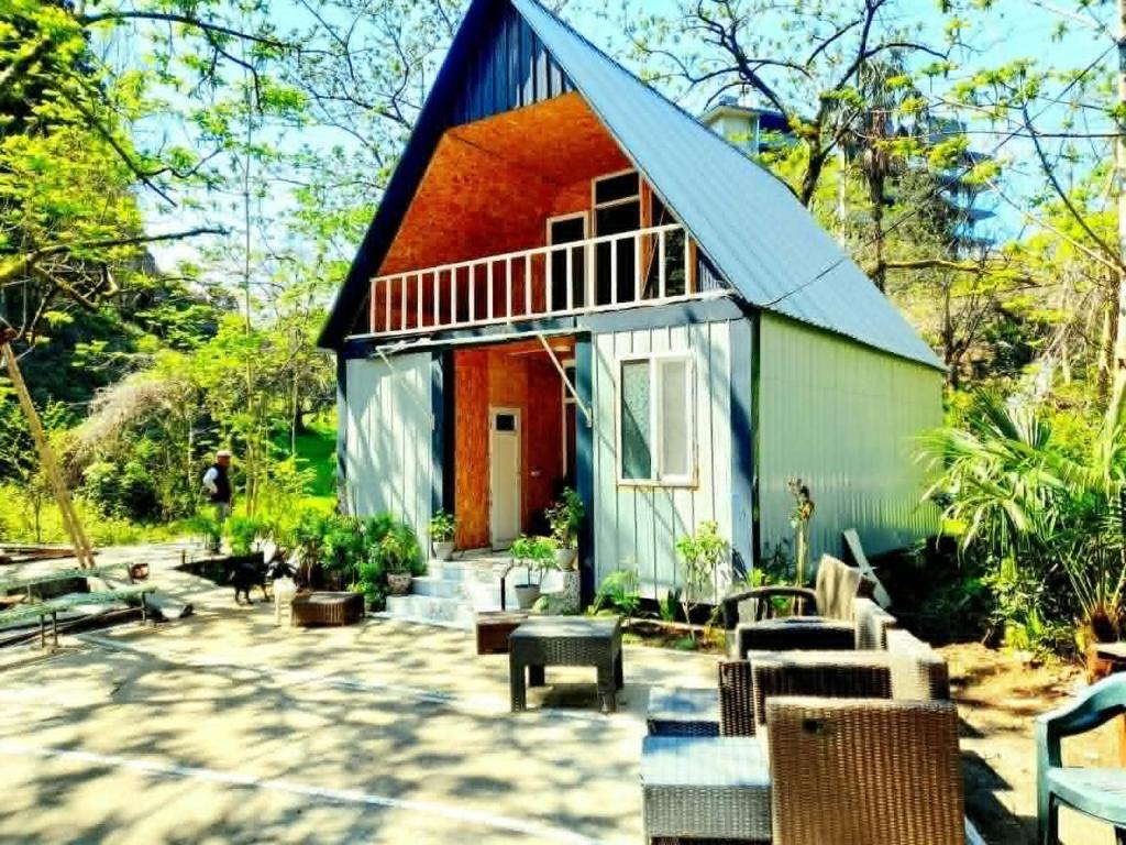 a house with a blue roof and a patio at Green House in Kobuleti