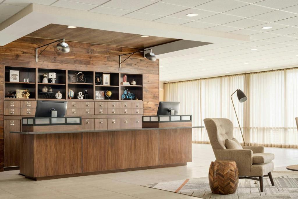 a lobby with a reception desk and a chair at Four Points by Sheraton Oakville in Oakville