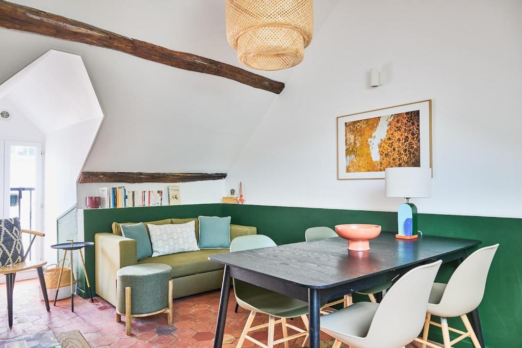 a living room with a table and a couch at Appartement Houdan centre-ville in Houdan