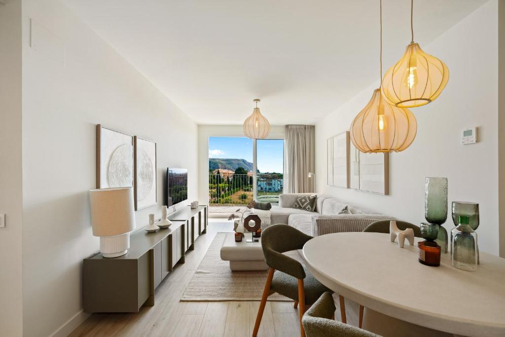 a living room with a table and a couch at Casa Costa Xàbia in Jávea