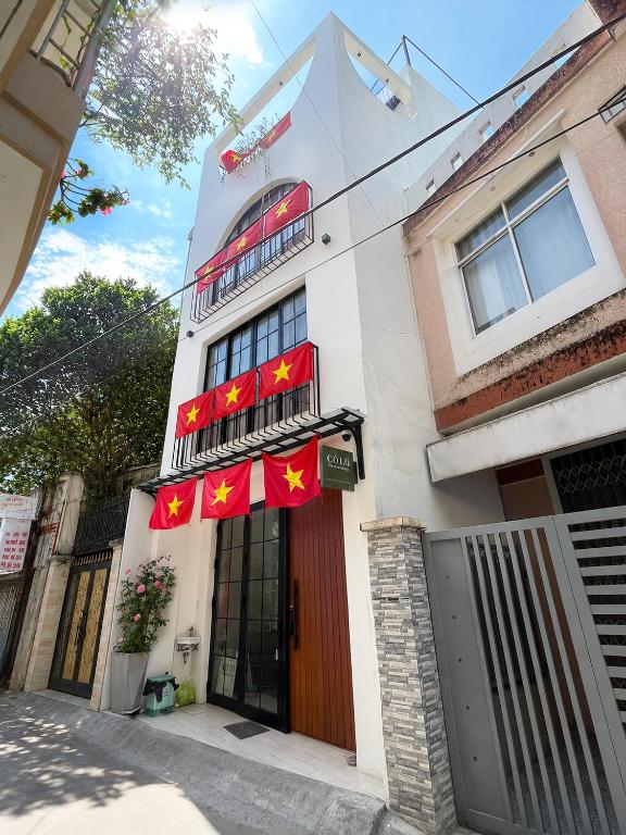 a white building with red flags on it at Cỏ Lá Homestay in Danang