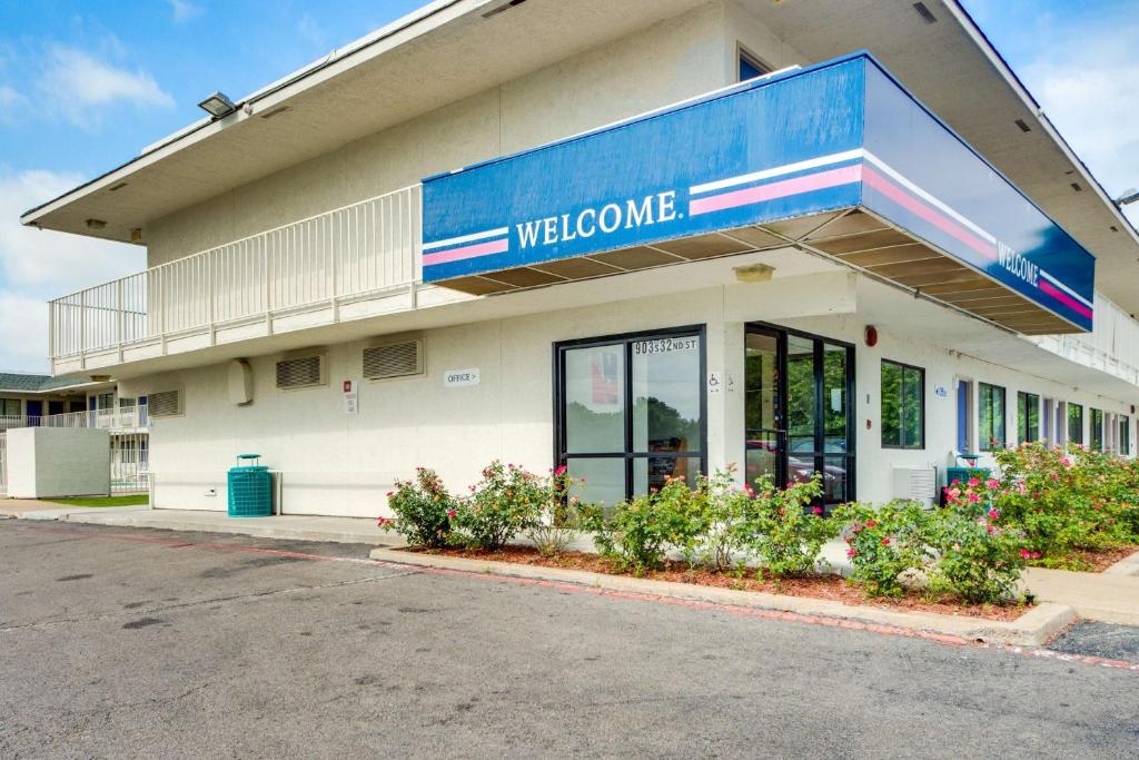 a welcome sign on the side of a building at Motel 6-Muskogee, OK in Muskogee