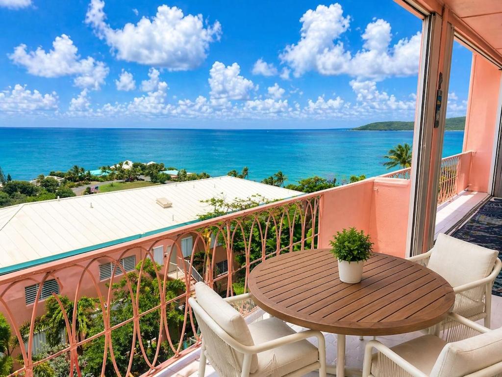 a balcony with a table and chairs and the ocean at East End Escape in Christiansted