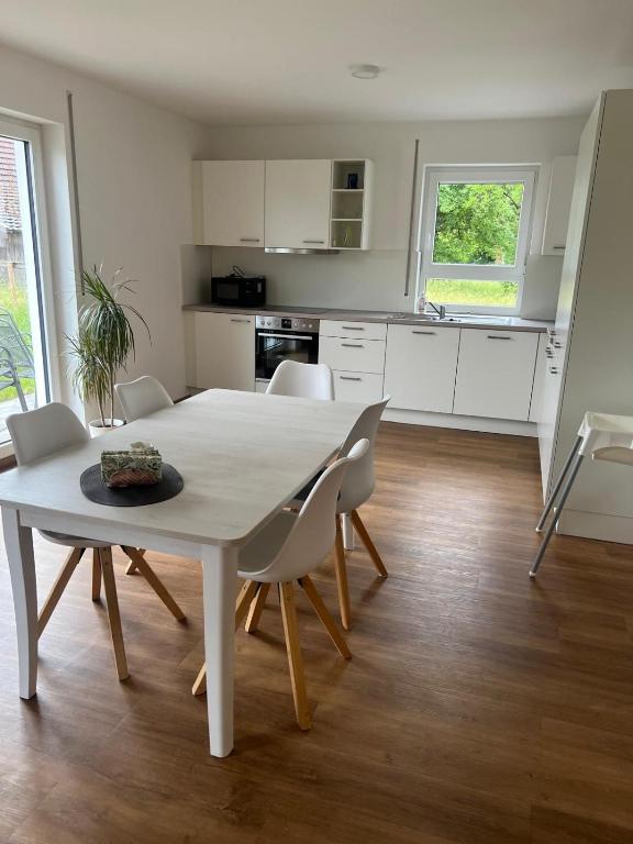 a kitchen and dining room with a table and chairs at Ferienwohnung Landhege in Michelfeld