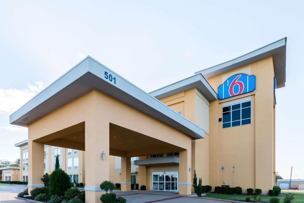 een hotel met een bord aan de voorzijde van een gebouw bij Motel 6-Joshua, TX in Joshua