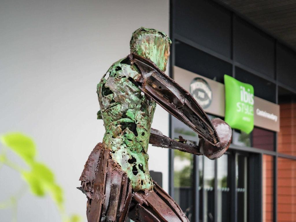 a statue of a person standing in front of a building at ibis Styles Castelnaudary in Castelnaudary