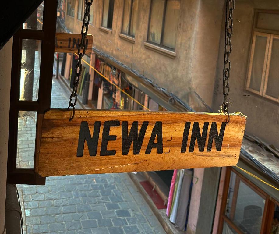 a wooden sign that says newza inn hanging from a building at Newa Inn Homestay in Kathmandu