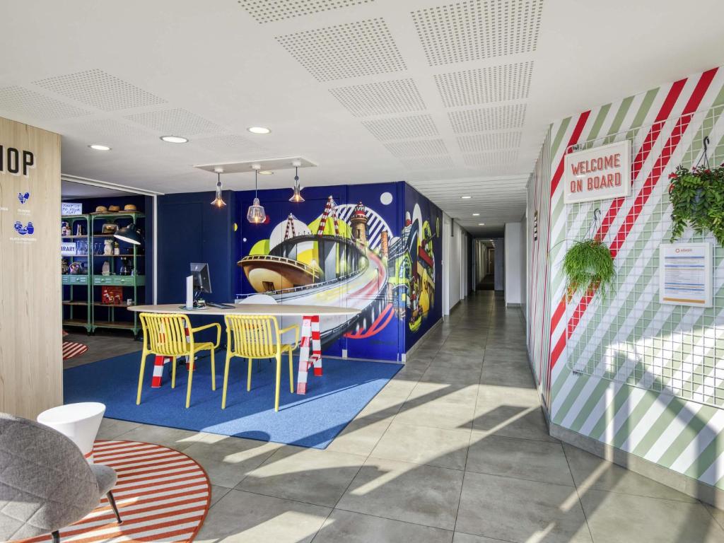 a dining room with a roller coaster mural on the wall at Aparthotel Adagio Access Saint Nazaire in Saint-Nazaire